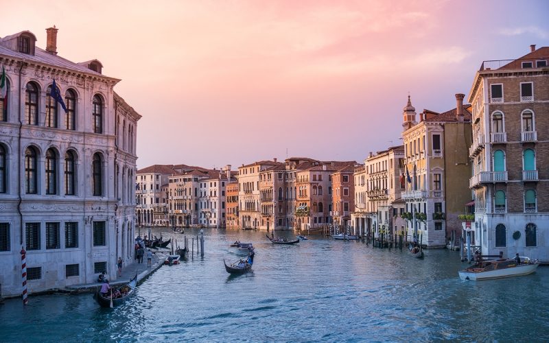 Venice canal with gondola at sundown