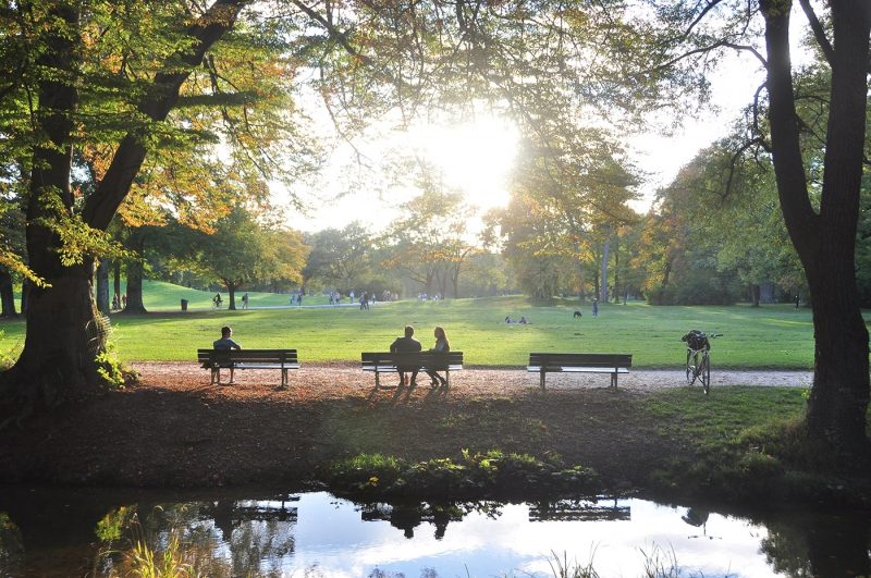 Couple sat on bench in Munich's English Garden