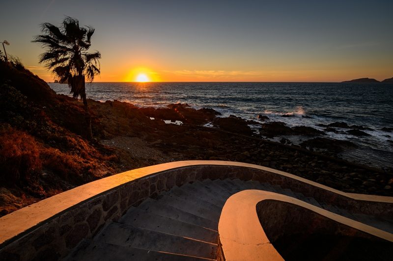 A curved stairway going down to Olas Altas beach at sunset in Mazatlan