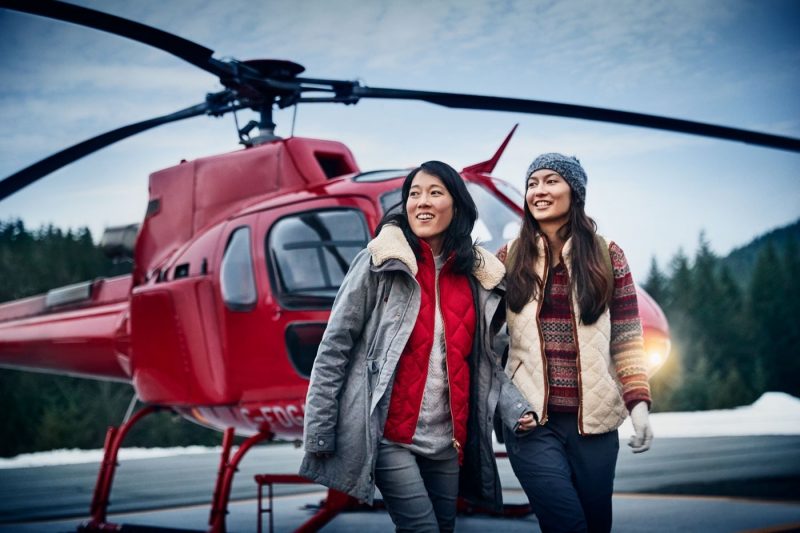 Two women in front of a helicopter as part of a Princess Cruises Alaska excursion