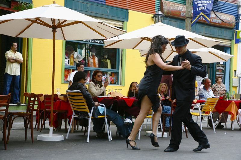 Couple dancing tango in the streets of La Boca outside a cafe