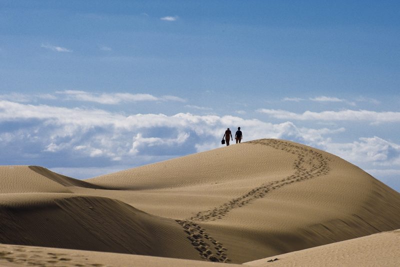 Two people on a sand dune