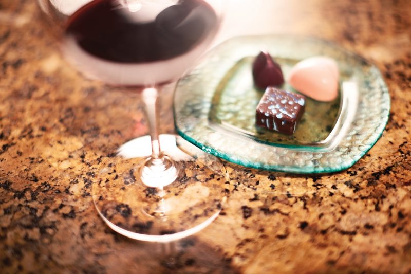 A glass of wine and a plate of chocolates