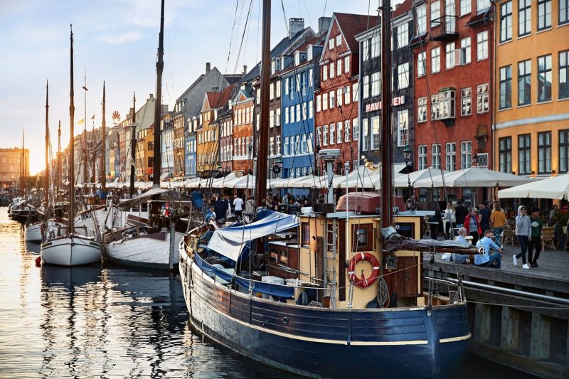 Boats on the water and colourful buildings along Nyhavn waterfront in Copenhagen