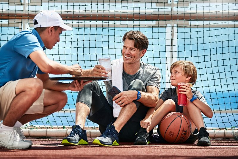 Father and son getting a drink after playing basketball