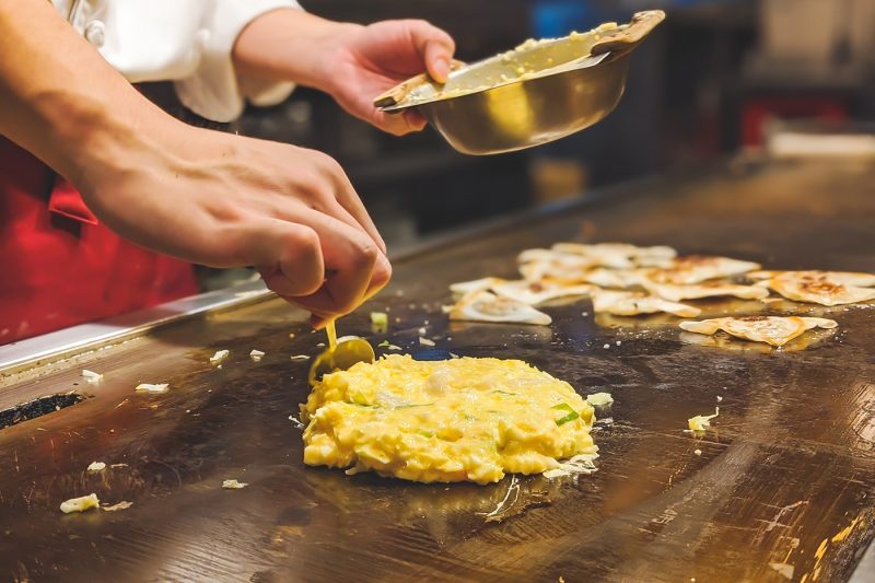 A chef preparing Okonomiyaki