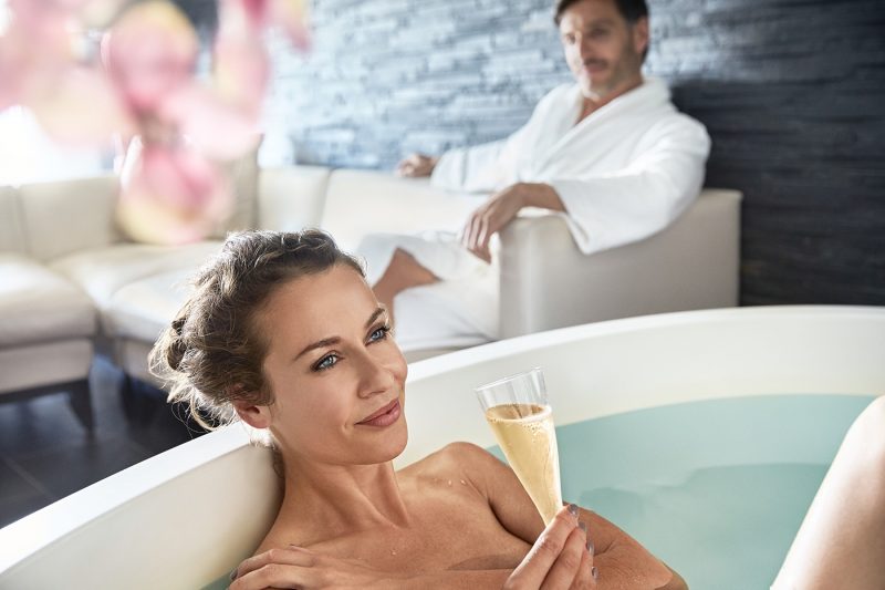 A woman relaxing in a spa with champagne