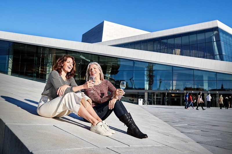 Friends drinking wine outside the Oslo Opera House