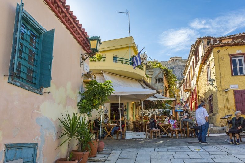 pastel coloured houses and cafe in Plaka District of Athens, overlooked by the Acropolis