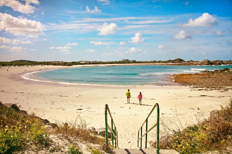 Two people walking on beach in Port Soif