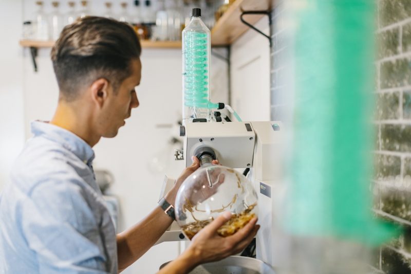 A man using the distilling equipment in the micro distillery at Porters gin