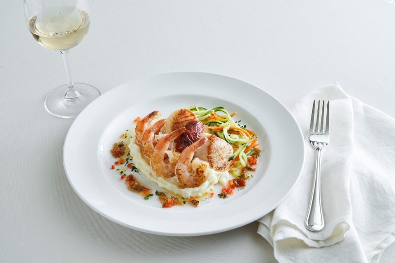 A dish of scallops and shrimps served with white wine from a Princess restaurant
