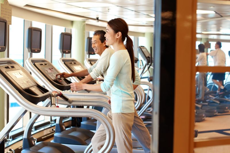 Couple using treadmill with screens