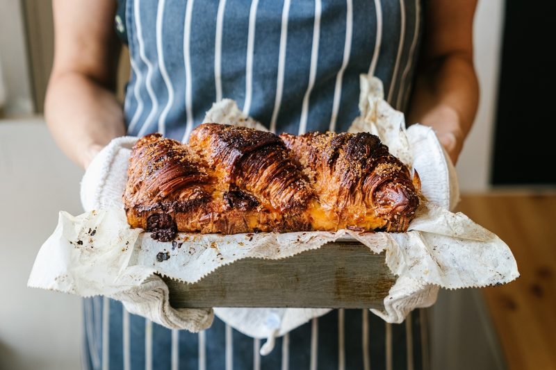 A baker holding freshly baked goods