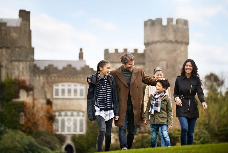 A family group walking in Dublin with a castle in the background