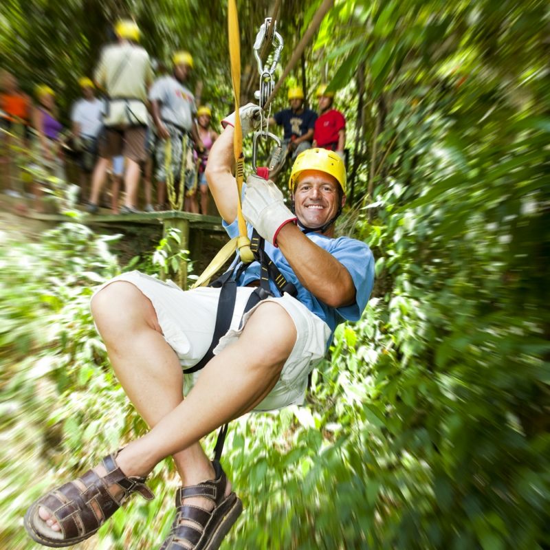 Man on a zipwire in trees in Honduras