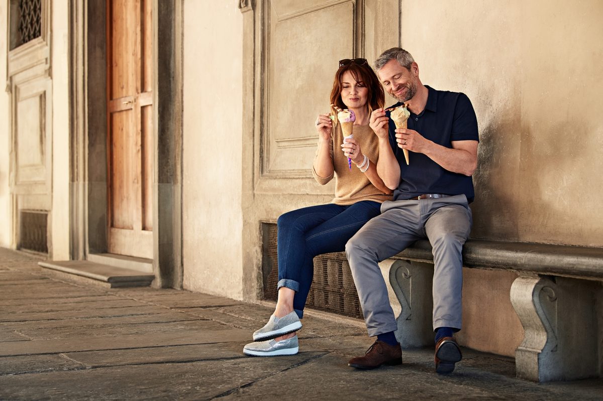 Couple eating ice cream sat on a bench