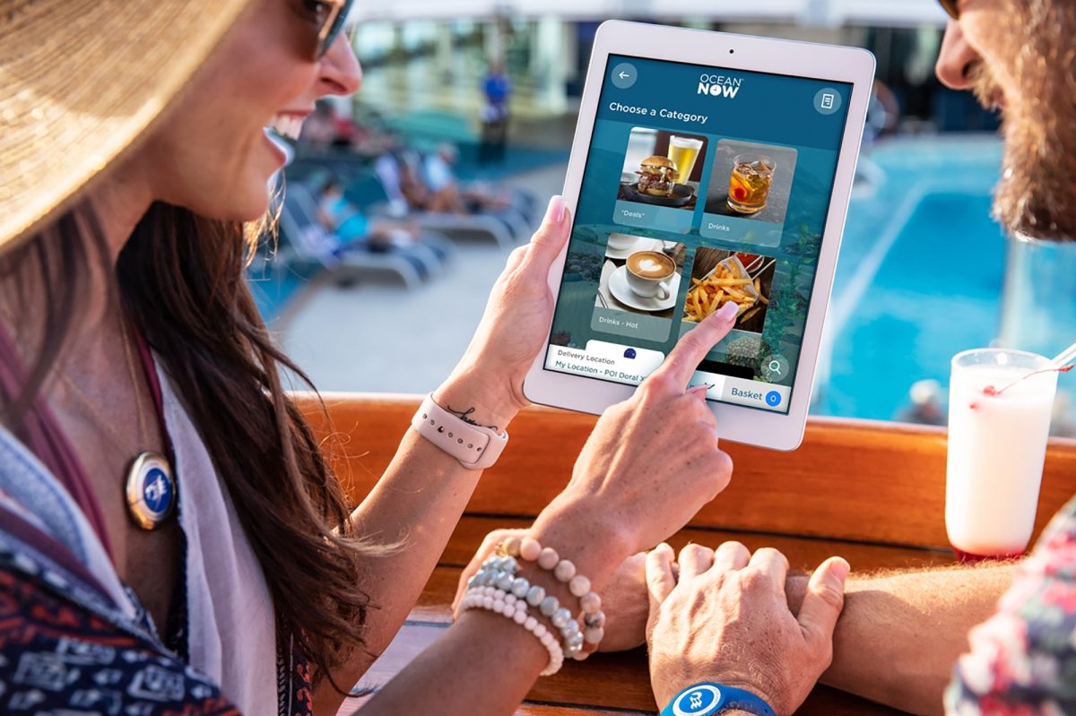 Two people using a tablet to order Ocean Medallion