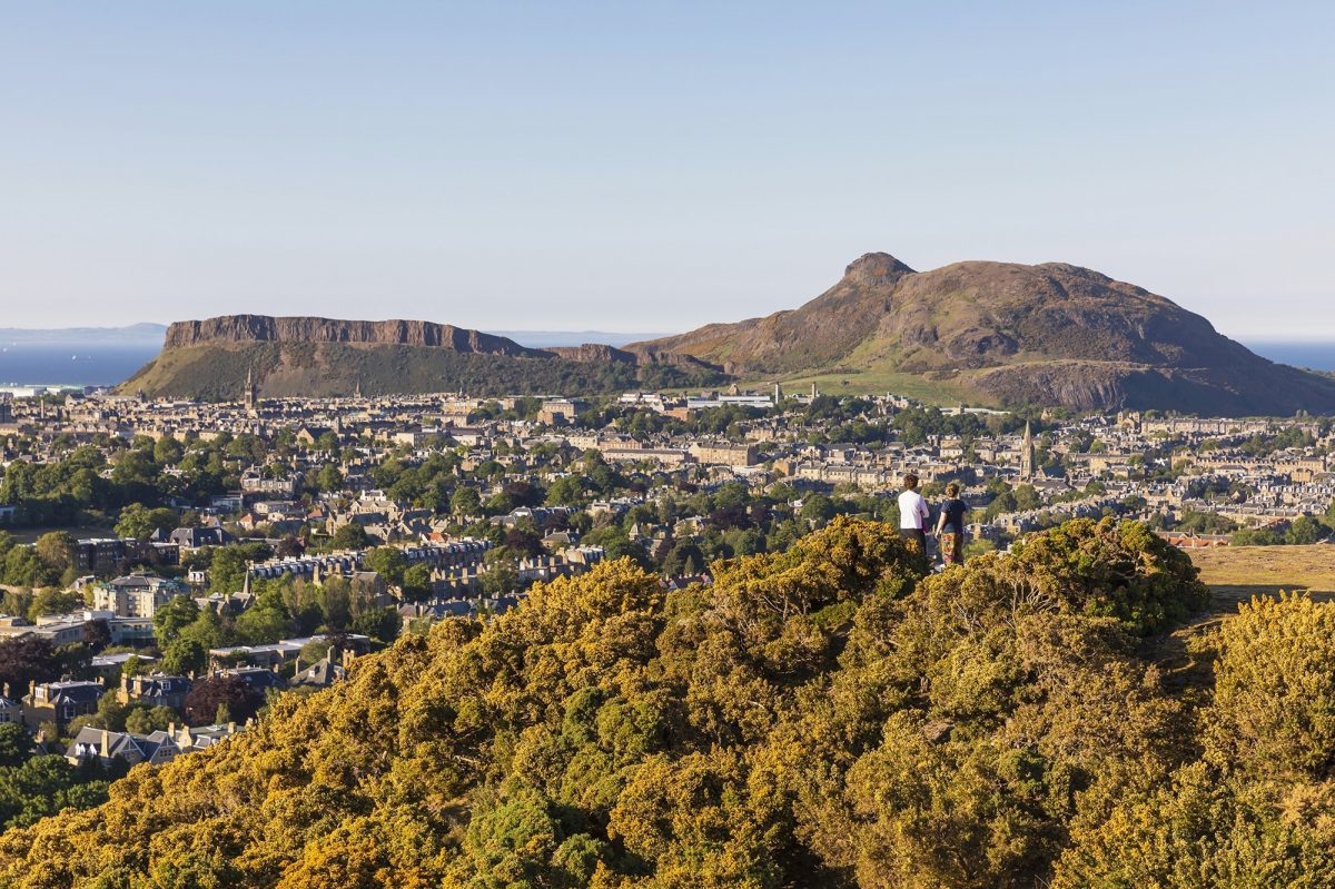 A couple on Blackford Hill look over the city toward Arthurs Seat