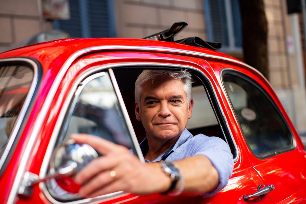 Phillip Schofiel driving a red Fiat car in Rome