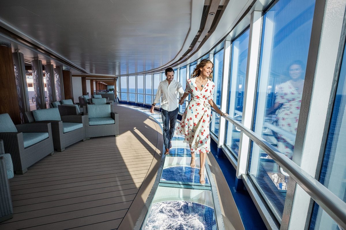 Two people walking on glass floor in ship
