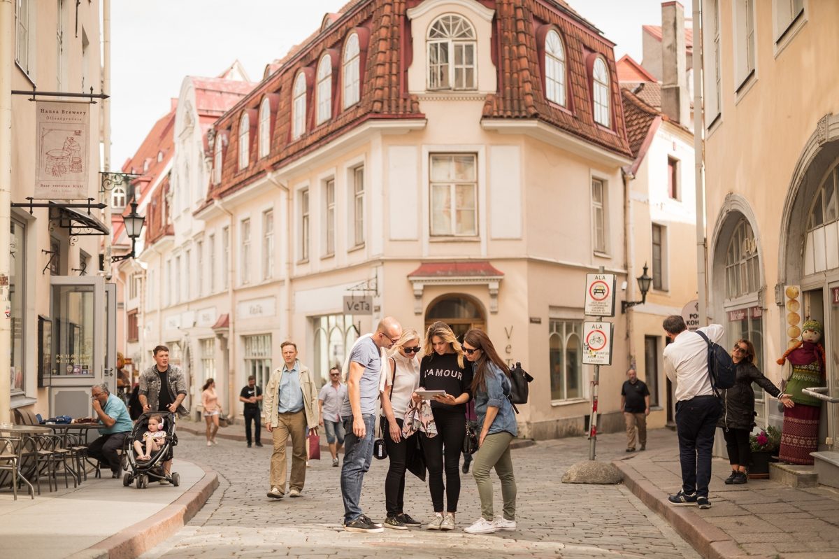 Group of four friends looking at iPad in streets of Tallinn