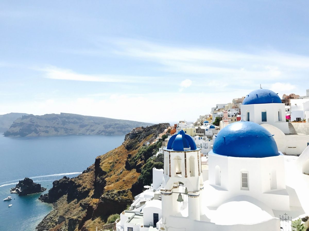 A view over Santorini featuring blue domes, cliffs and the sea