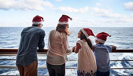 Family on deck of ship wearing santa hats