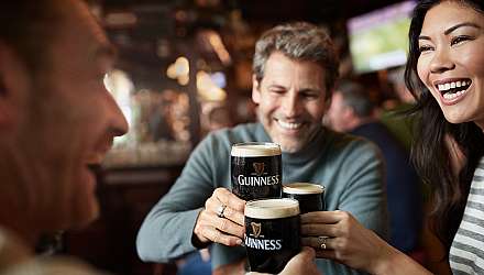 Three friends drinking Guiness in a pub in Dublin
