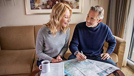 A couple with a map planning a cruise holiday