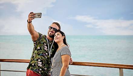 Couple taking photo with mobile phone on deck
